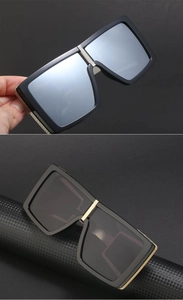Detail of steampunk square sunglasses with gold metal accents and dark mirror lenses