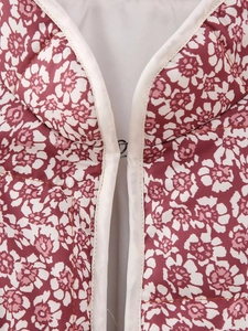 Detailed close-up of quilted floral jacket neckline with white trim and metal hook closure