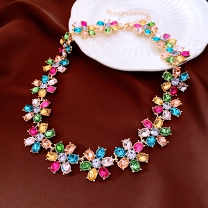 Detail of vintage flower necklace with colorful gemstones and metal chain on fabric