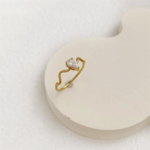 Detailed macro view of gold plated wavy ring with a teardrop cubic zirconia stone.
