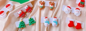 Close-up of cute Christmas theme clip-on earrings with festive cartoon characters