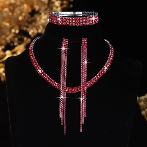 Macro detail of luxury red rhinestone necklace, bracelet, and earring set on black velvet