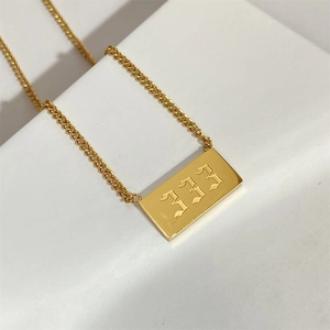 Macro shot of gold square pendant with gothic 333 engraving on a high quality link chain