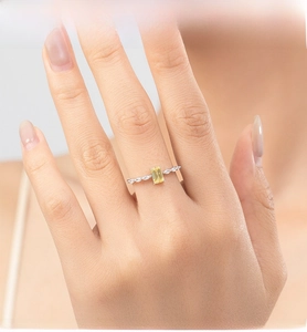 Close-up of s925 silver ring with rectangular yellow gemstone on female finger