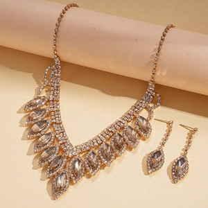 Close-up of gold drop fringe necklace and earring set with shimmering rhinestones