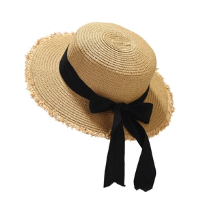 Women's raffia sun hat with black bow and frayed edge for beach vacations