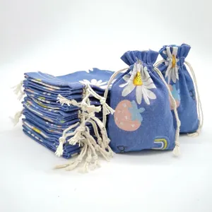 Close-up of blue cotton drawstring gift bags with daisy and strawberry prints