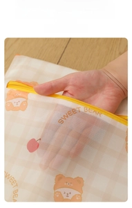 Close-up of Butter Bear laundry bag showing breathable fine mesh and yellow zipper