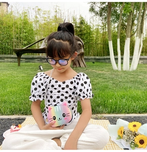 Kid's crossbody bag featuring a cute rainbow gradient cat design on a park lawn