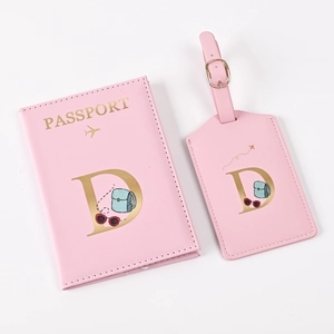 Pink passport cover and luggage tag set with gold letter D and travel motifs