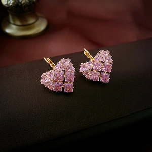 Macro shot of French luxury style heart hoop earrings with pink zircon and gold finish