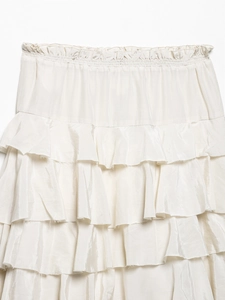 Close-up of elastic waist and tiered ruffle details on a creamy white satin midi skirt