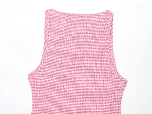 Détail de la texture du tissu vichy rose et blanc en seersucker sur une robe midi