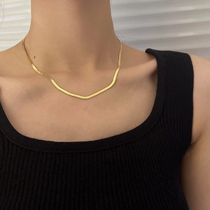 Close-up of golden double-layer snake bone chain necklace worn on the collarbone