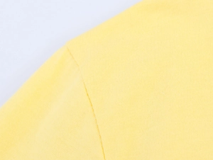Dettaglio della cucitura della spalla di alta qualità su una maglietta in cotone giallo