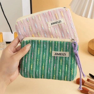 Pink and green knit makeup bags with woven texture and a purple lanyard strap