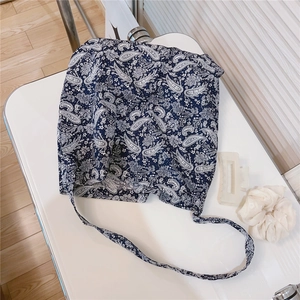 Detail of navy blue cotton crossbody bag featuring white paisley floral patterns