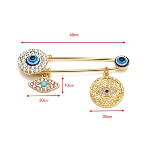 Detailed size chart for golden evil eye brooch pin featuring crystal charms and 68mm length