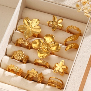 Collection of minimalist 18k gold plated stainless steel floral rings in a jewelry box
