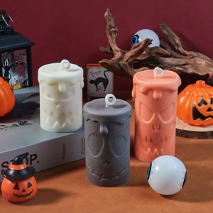 Close-up of Halloween candles with carved skull and ghost faces in festive atmosphere