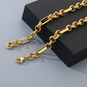 Detail of a gold stainless steel Figaro chain necklace with a secure lobster clasp