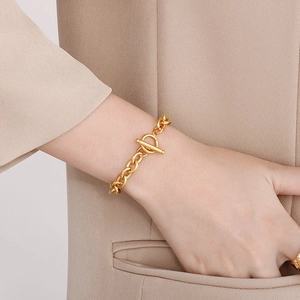 Detailed shot of a gold-plated stainless steel link chain bracelet with toggle clasp
