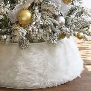 Close-up of fluffy white faux fur Christmas tree skirt on rustic wooden floor