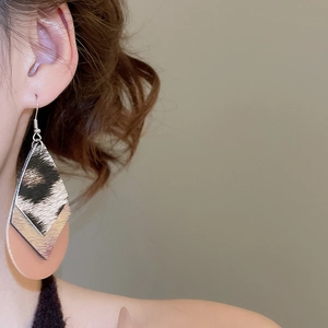 Close-up of leopard print teardrop earrings with multi-layer geometric fringe design