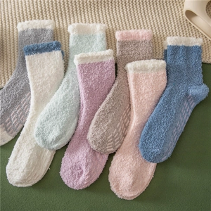 Detailed close-up of fluffy coral fleece socks with purple non-slip grippers on soles