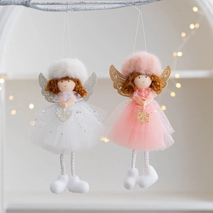 Close-up of plush angel dolls with sequin gauze skirts hanging on white branches