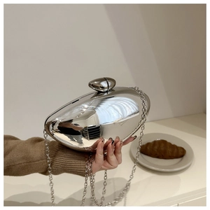 Close-up of a silver metallic mango-shaped clutch bag with sleek chain strap detail