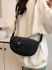 Bolso bandolera de media luna en nailon negro minimalista con correa y logo bordado