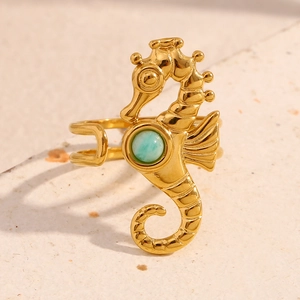Detailed macro shot of a gold seahorse ring featuring a blue stone and textured scales