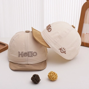 Détail des broderies Hello et sourire sur des casquettes de baseball pour bébé