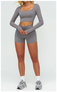 Dettaglio degli shorts da yoga con vita a V incrociata e crop top coordinato a maniche lunghe