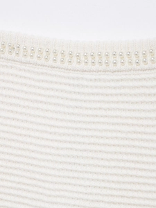 Détail d'ensemble jupe en tricot blanc avec texture côtelée et perles élégantes