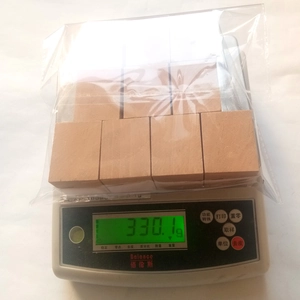 Weight measurement of 10-piece wooden postcard bases in a plastic bag on a digital scale
