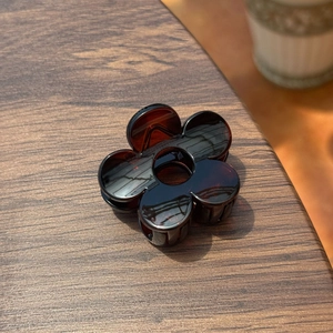 Détail d'une pince à cheveux fleur de 5 cm en résine ambre marron au style rétro