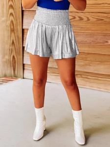 Detail of high waisted silver metallic shorts featuring an elastic gathered waistband