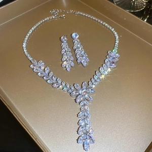 Macro view of silver wheat ear tassel necklace and earrings set on a metal tray