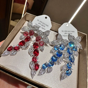 Detailed close-up of 925 silver leaf tassel earrings with red and blue zircon stones