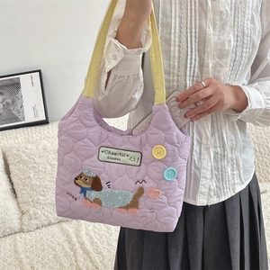 Detalle del bolso acolchado morado con bordado de perro salchicha y correa amarilla