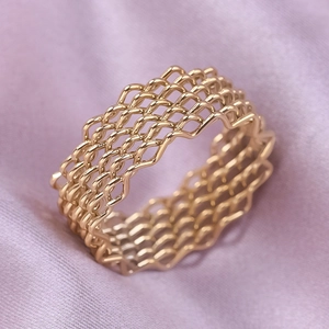 Macro shot of 18K gold plated stainless steel mesh ring with woven wave patterns
