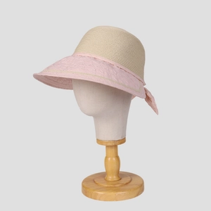 Detail of the pink fabric brim with subtle textures and a sweet bow on the straw sun hat