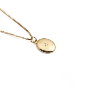 Goldene ovale Halskette mit sternförmigem Diamantanhänger und Box-Kette auf Weiß
