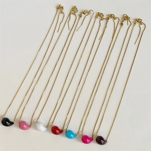 Detailed close-up of colorful enamel water drop bean pendants on golden box chains