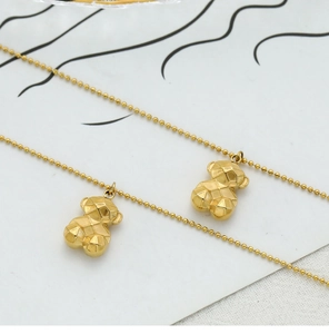 Close-up of golden geometric 3D bear pendant featuring a classic polished ball chain