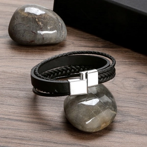 Detail of multi-layer black braided leather bracelet with silver magnetic metal clasp