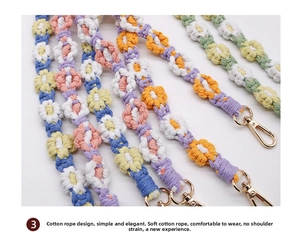 Detail of colorful hand-woven cotton strap with flower patterns and golden metal clasps