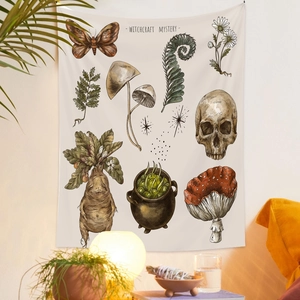 Detail of bohemian tapestry featuring moth and fern illustrations in a cozy room setting